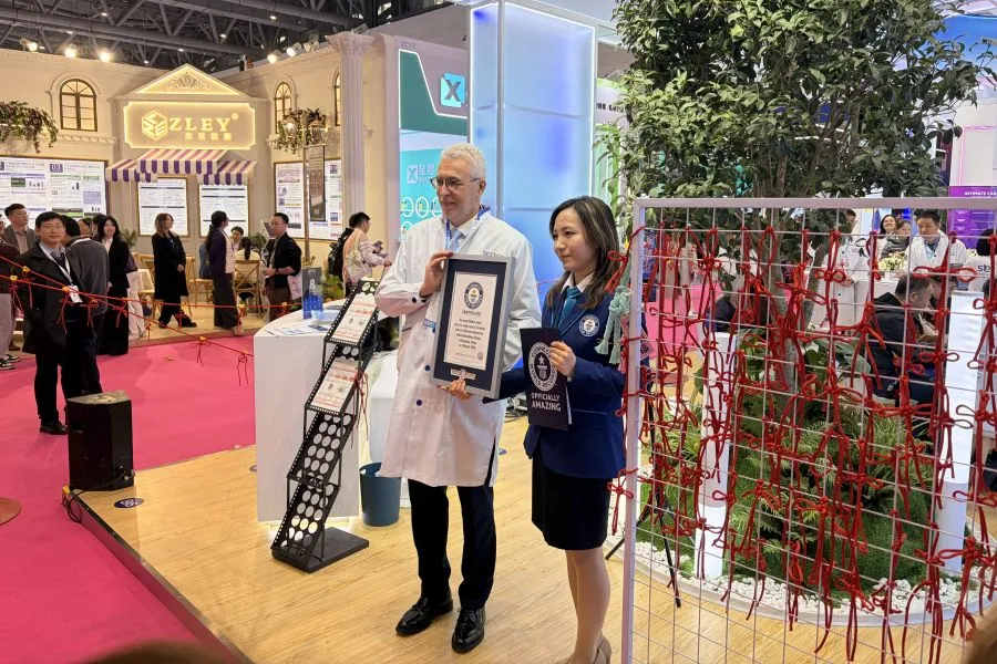 Two people smiling holding plaques.